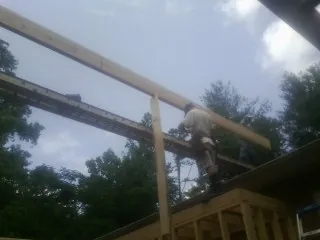 Carpenter setting a ridge beam over a new addition frame — Ice Dam Removal by Roofing Brothers in Englewood Cliffs