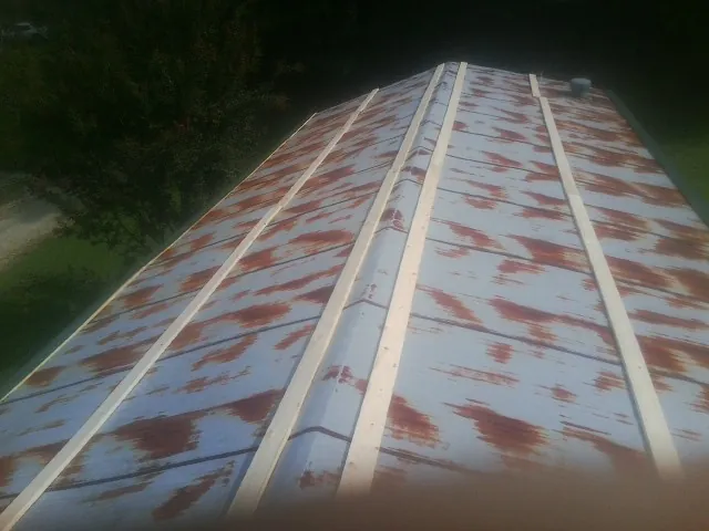 Rusted metal roof panels with new wood purlins before replacement — Storm Damage Roof Repair in Englewood Cliffs by Roofing Brothers
