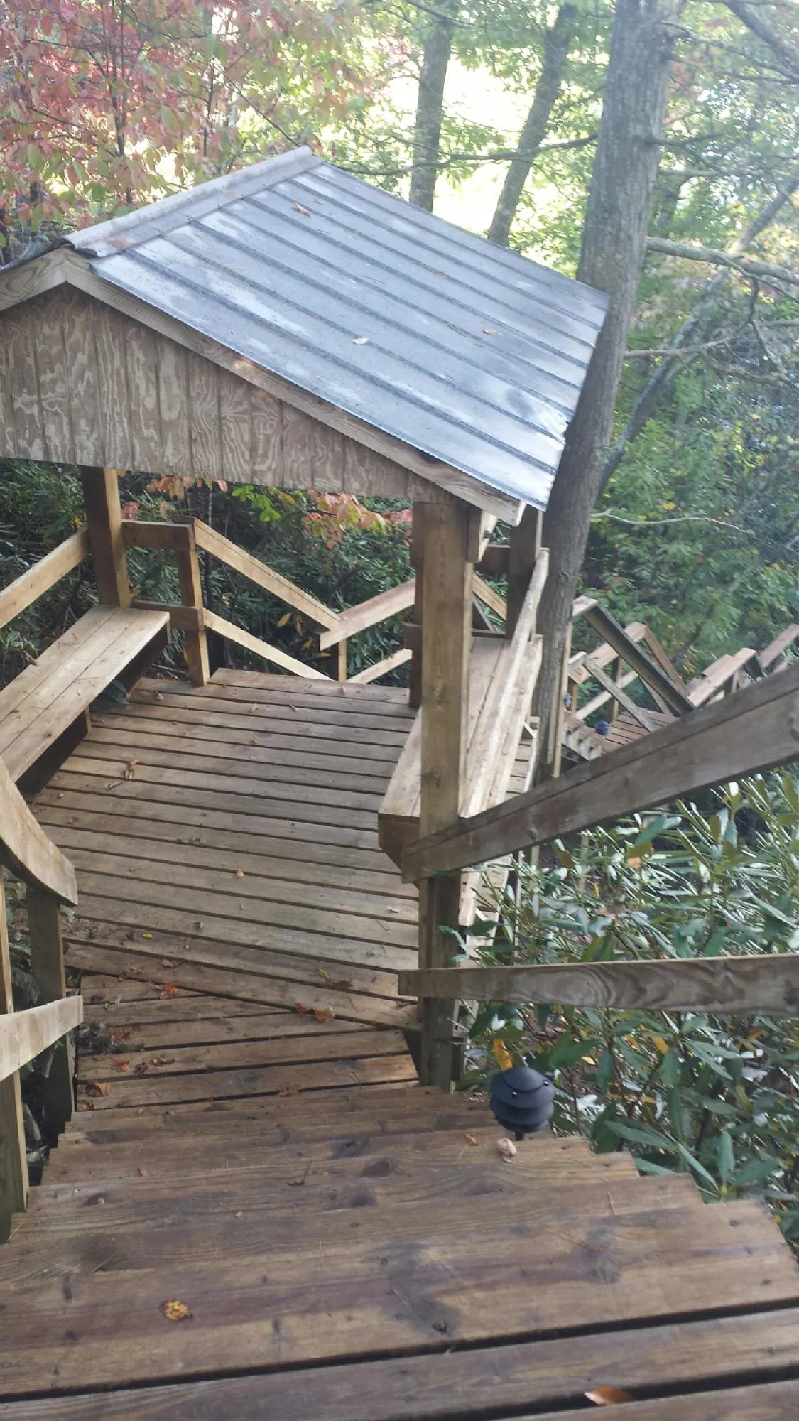 Metal roofed shelter over wooden steps on a wooded walkway — Skylight Repair & Installation work by our crew in Englewood Cliffs