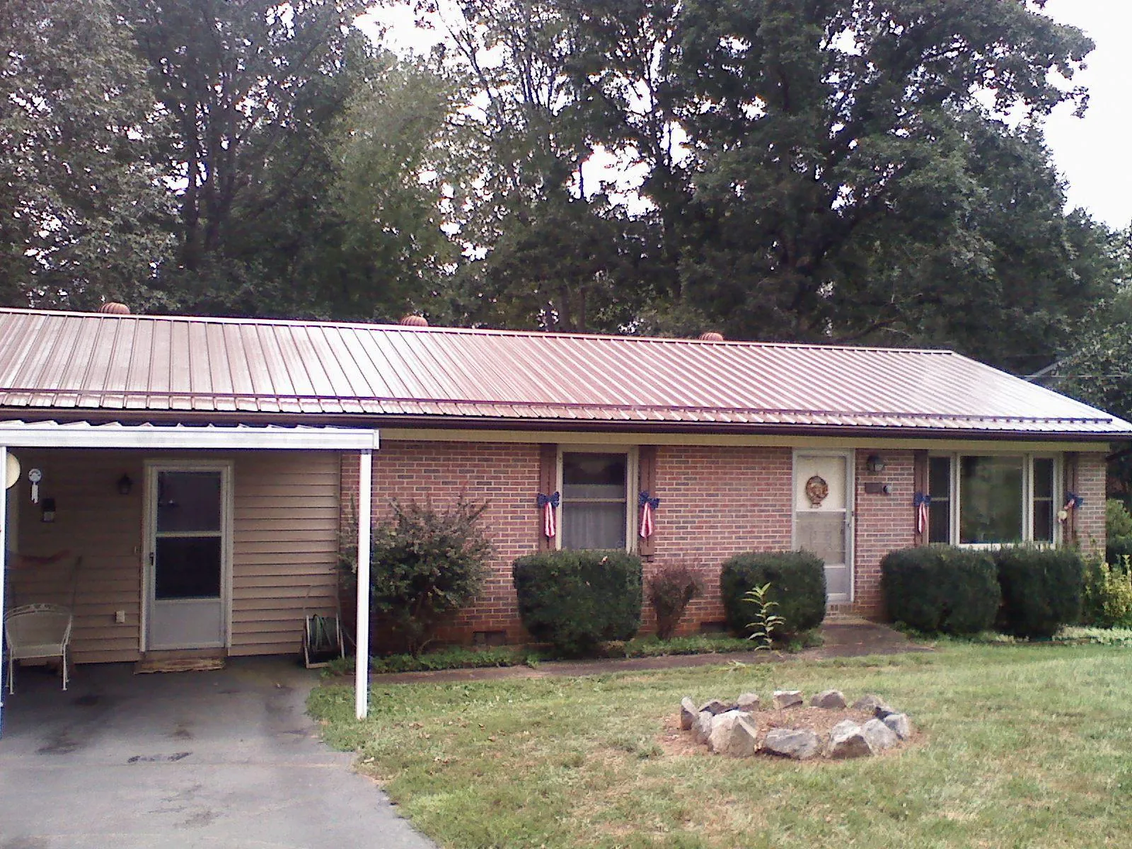 Bronze metal roof and carport on a brick ranch home — Roof Repair work by our crew in Englewood Cliffs
